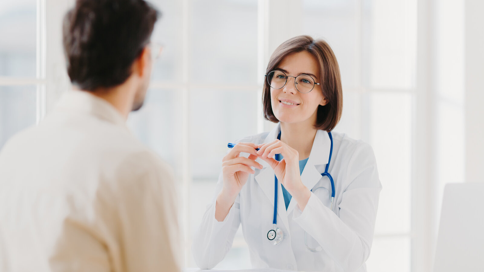 Consultation médicale : un médecin et un patient échangent autour d’un bureau
